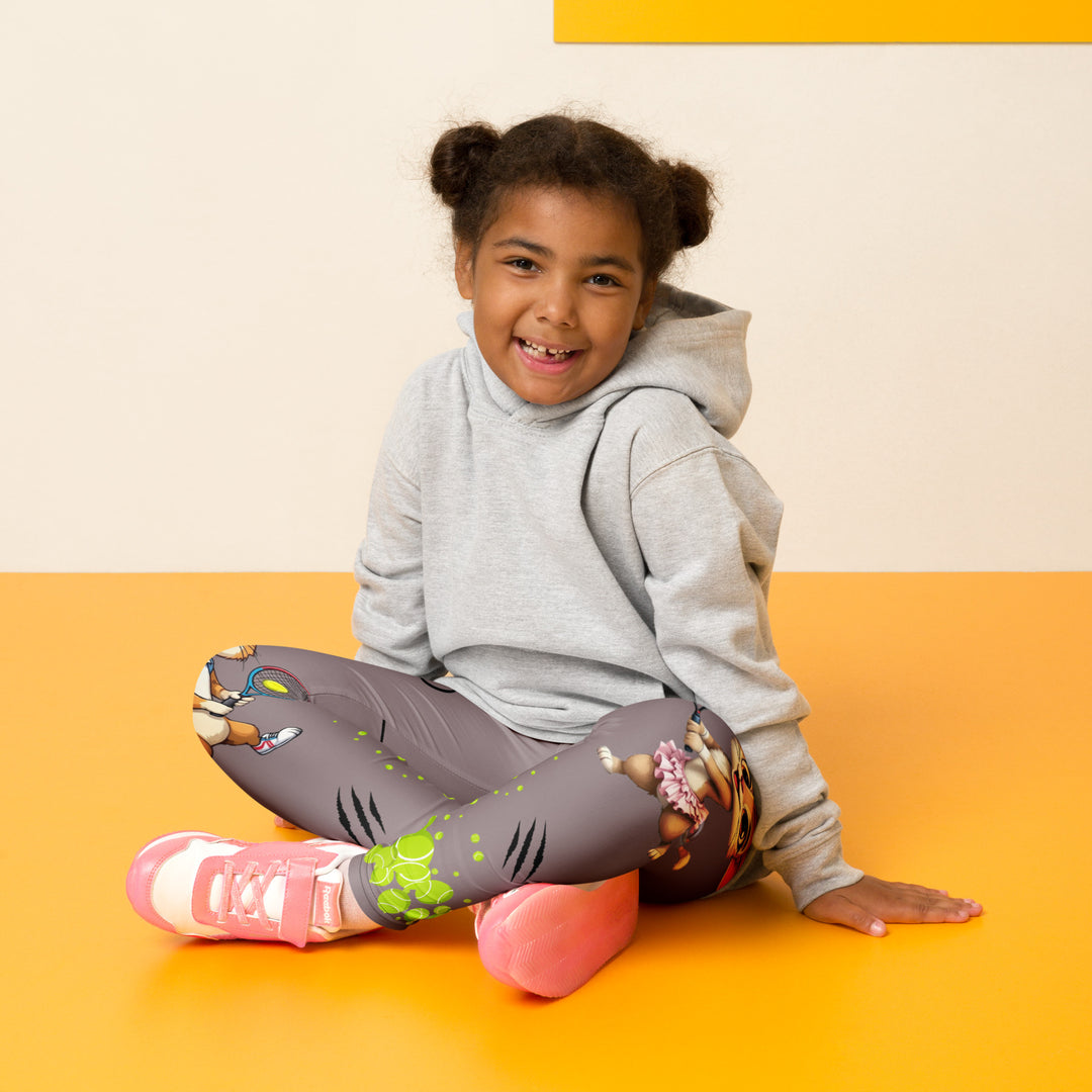 Tennis Kittens Girls Leggings, dark gray background with a cat holding a tennis racket on one leg and a kitten with a tennis racket on the other leg, each racket with a tennis ball as if playing, dressed in sporty outfits, with neon green tennis balls, hearts, and "love" text, seated pose on model