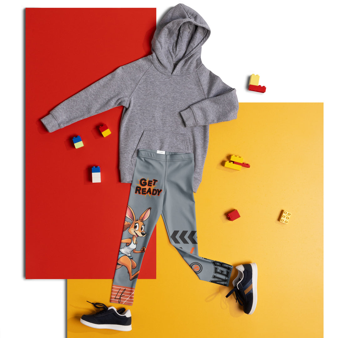Track Runner Kangaroo Girls Leggings, dark gray background with a sporty kangaroo running on an orange track on one leg, "get ready" text in black and orange above, and an orange and black medal with "runner" text in the lower corner on the other leg, front view laid flat on floor