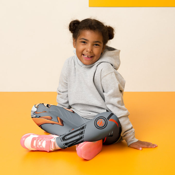 Track Runner Kangaroo Girls Leggings, dark gray background with a sporty kangaroo running on an orange track on one leg, "get ready" text in black and orange above, and an orange and black medal with "runner" text in the lower corner on the other leg, seated pose on model