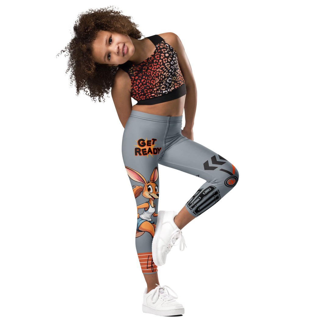  Track Runner Kangaroo Girls Leggings, dark gray background with a sporty kangaroo running on an orange track on one leg, "get ready" text in black and orange above, and an orange and black medal with "runner" text in the lower corner on the other leg, side view with one leg lifted and bent on model