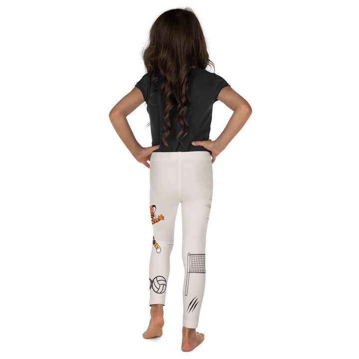  Volley Queen Tiger Girls Leggings, beige background with one leg featuring a sporty dressed tiger holding a volleyball, and the other leg with a volleyball net and a ball leaving a motion trail, back view on model