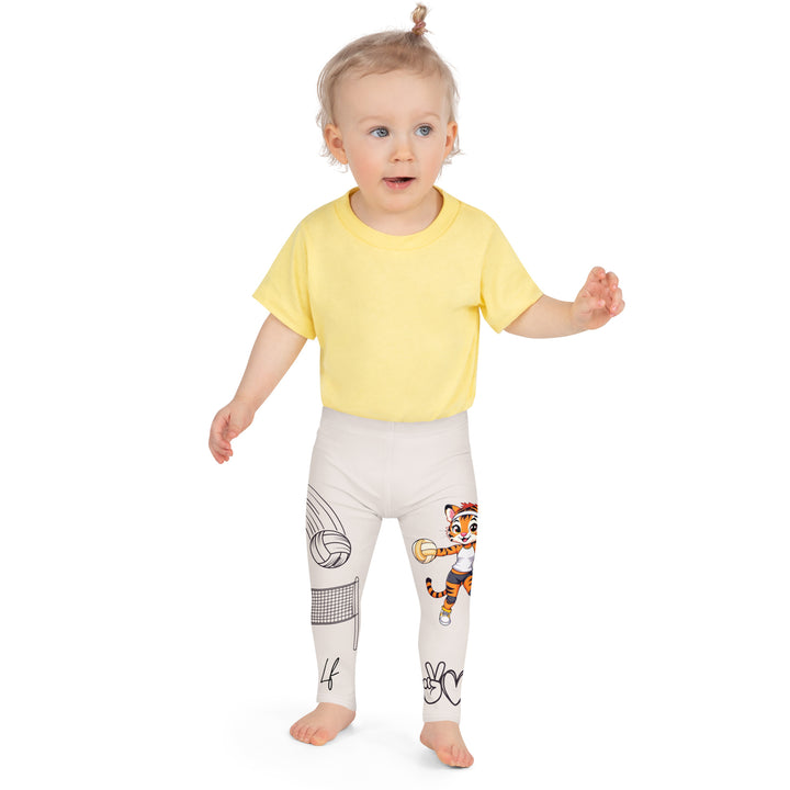 Volley Queen Tiger Girls Leggings, beige background with one leg featuring a sporty dressed tiger holding a volleyball, and the other leg with a volleyball net and a ball leaving a motion trail, front close-up view on model