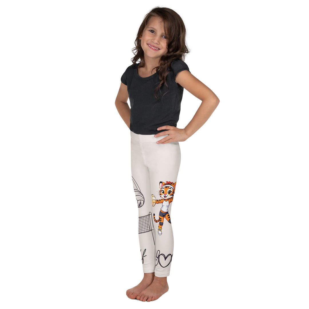 Volley Queen Tiger Girls Leggings, beige background with one leg featuring a sporty dressed tiger holding a volleyball, and the other leg with a volleyball net and a ball leaving a motion trail, left side view on model