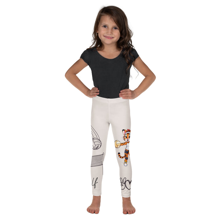 Volley Queen Tiger Girls Leggings, beige background with one leg featuring a sporty dressed tiger holding a volleyball, and the other leg with a volleyball net and a ball leaving a motion trail, relaxed front pose on model
