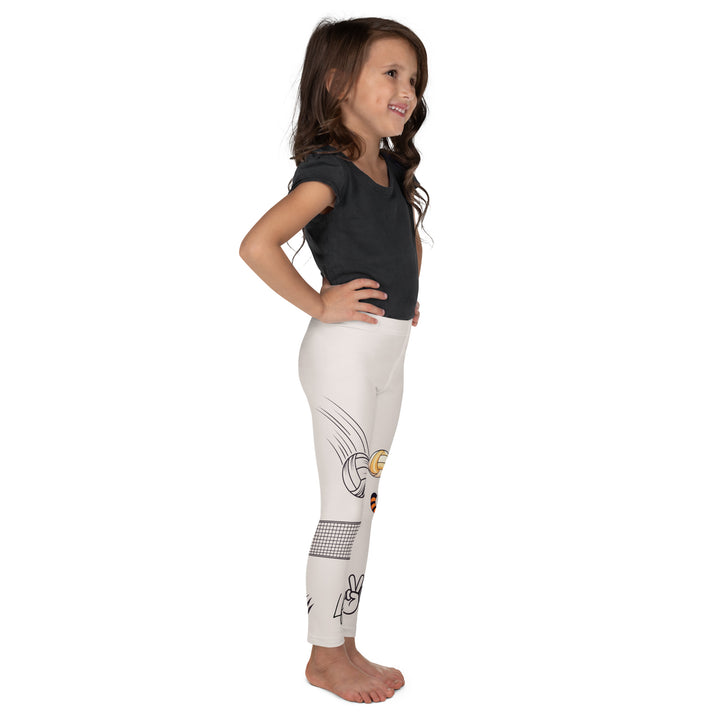  Volley Queen Tiger Girls Leggings, beige background with one leg featuring a sporty dressed tiger holding a volleyball, and the other leg with a volleyball net and a ball leaving a motion trail, right side view on model
