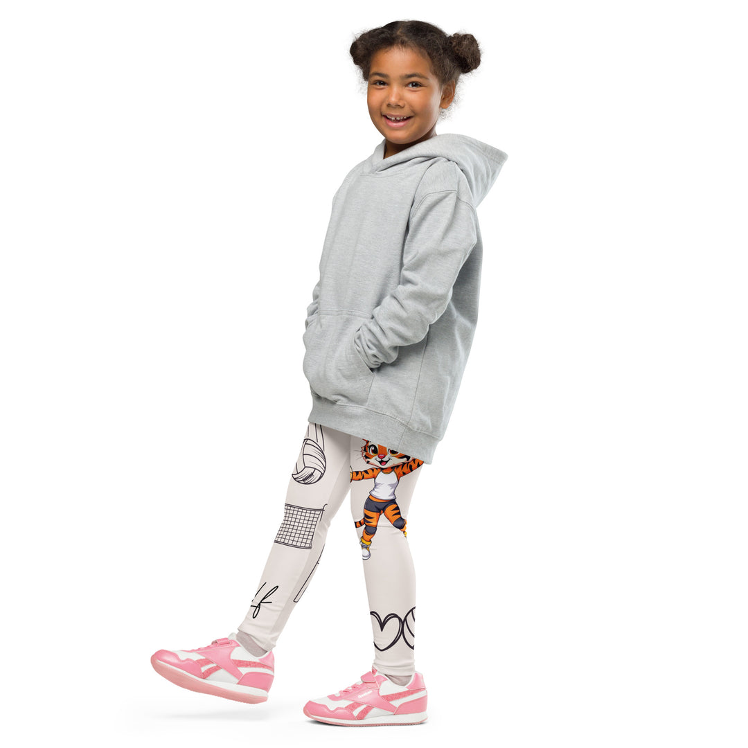 Volley Queen Tiger Girls Leggings, beige background with one leg featuring a sporty dressed tiger holding a volleyball, and the other leg with a volleyball net and a ball leaving a motion trail, side view with one leg lifted and extended on model