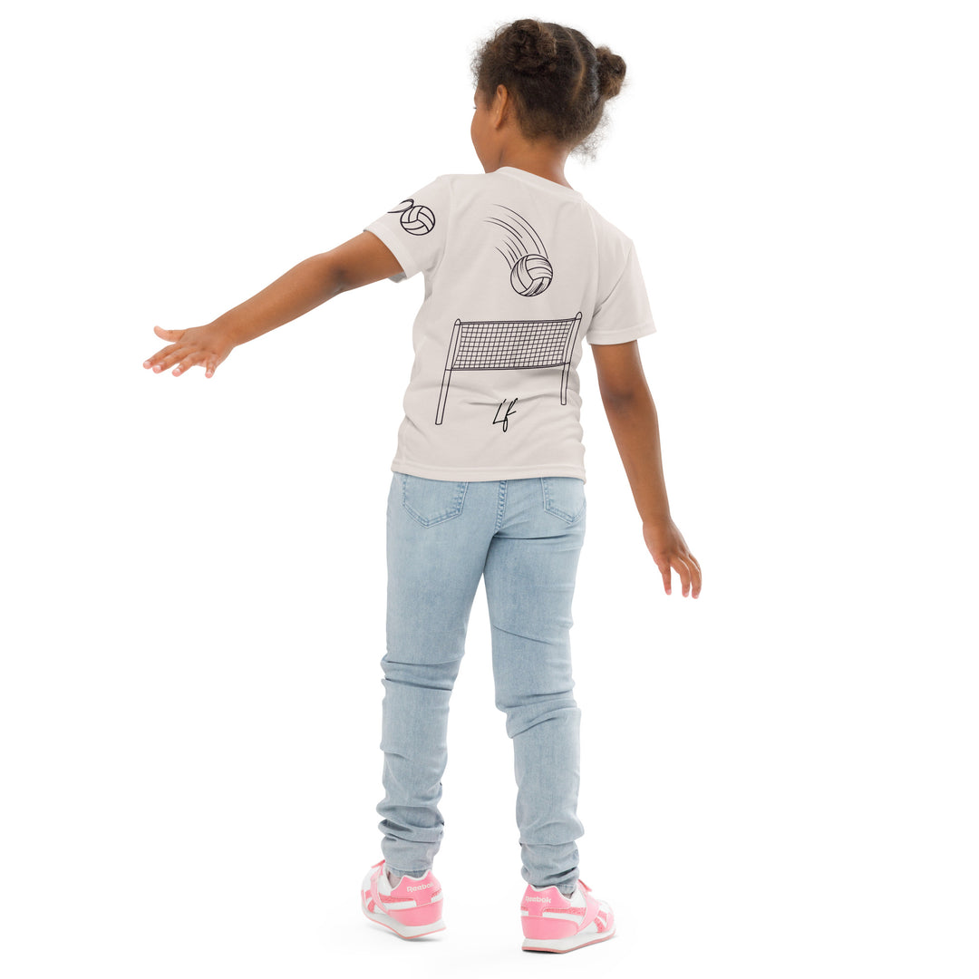 Volley Queen Tiger Girls T-shirt, beige background with a sporty dressed tiger holding a volleyball on the front, a heart, volleyball, and peace sign on the left sleeve, and a volleyball net with a ball leaving a motion trail on the back, back angle with relaxed pose on model