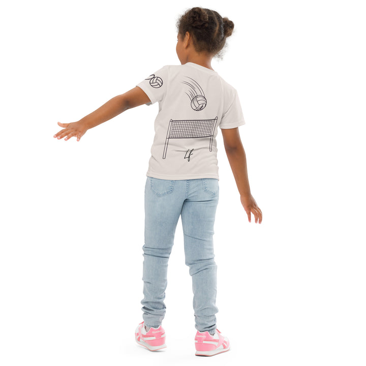Volley Queen Tiger Girls T-shirt, beige background with a sporty dressed tiger holding a volleyball on the front, a heart, volleyball, and peace sign on the left sleeve, and a volleyball net with a ball leaving a motion trail on the back, back angle with relaxed pose on model