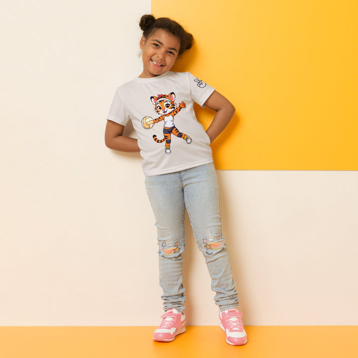 Volley Queen Tiger Girls T-shirt, beige background with a sporty dressed tiger holding a volleyball on the front, a heart, volleyball, and peace sign on the left sleeve, and a volleyball net with a ball leaving a motion trail on the back, relaxed front pose on model