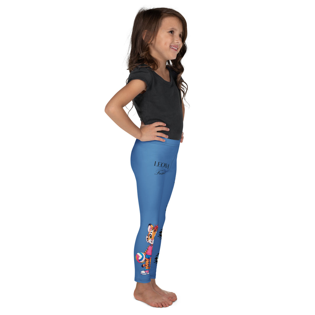Volleyball Tiger Girls Leggings, blue background with a sporty dressed tiger holding a volleyball on one leg, and colorful glowing volleyballs on the other leg, right side view on model-with a visible 'Leona Fashion' text on the design