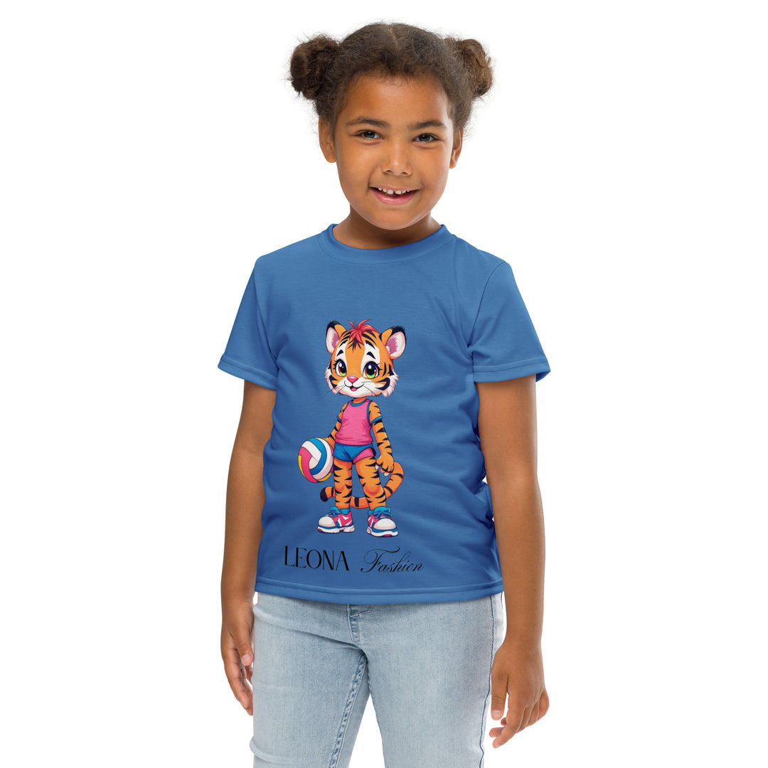 Volleyball Tiger Girls T-shirt, blue background with a sporty dressed tiger holding a volleyball on the front, and colorful glowing volleyballs on the back, front pose with arms at sides on model-with a visible 'Leona Fashion' text on the design