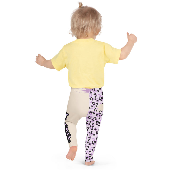 Wild Kitty Paw Purple Girls Leggings, cream background with a black panther featuring soft lavender spots on one leg, and a black and lavender tiger-striped pattern with a large matching paw on the other leg, mixed with cream details, back pose on model