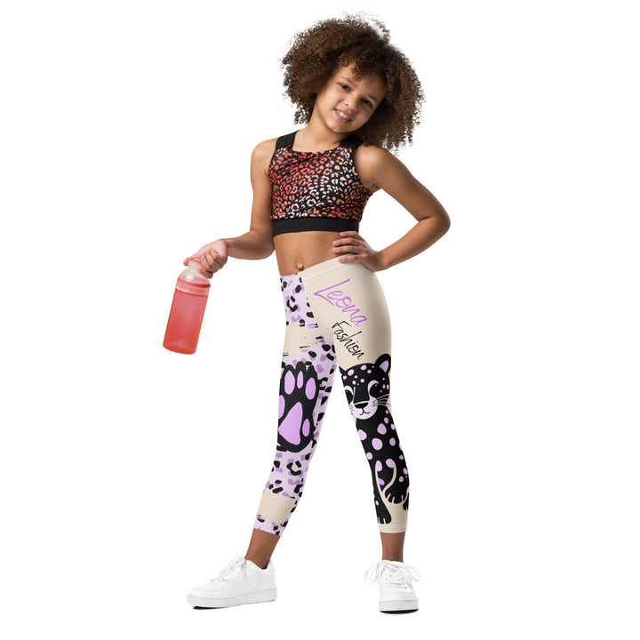 Wild Kitty Paw Purple Girls Leggings, cream background with a black panther featuring soft lavender spots on one leg, and a black and lavender tiger-striped pattern with a large matching paw on the other leg, mixed with cream details, front view on model-with a visible 'Leona Fashion' text on the design