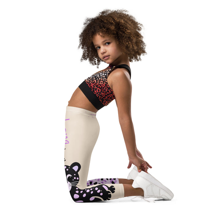 Wild Kitty Paw Purple Girls Leggings, cream background with a black panther featuring soft lavender spots on one leg, and a black and lavender tiger-striped pattern with a large matching paw on the other leg, mixed with cream details, left side view kneeling on model-with a visible 'Leona Fashion' text on the design