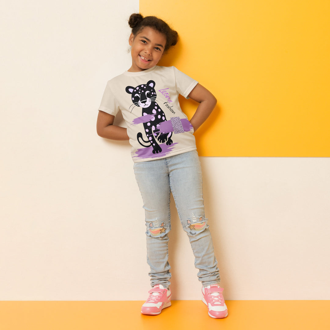  Wild Kitty Paw Purple Girls T-shirt, cream background with a black panther featuring soft lavender spots, accented by lavender brushstroke shapes and a cream tiger-print rectangular pattern, relaxed front pose on model-with a visible 'Leona Fashion' text on the design