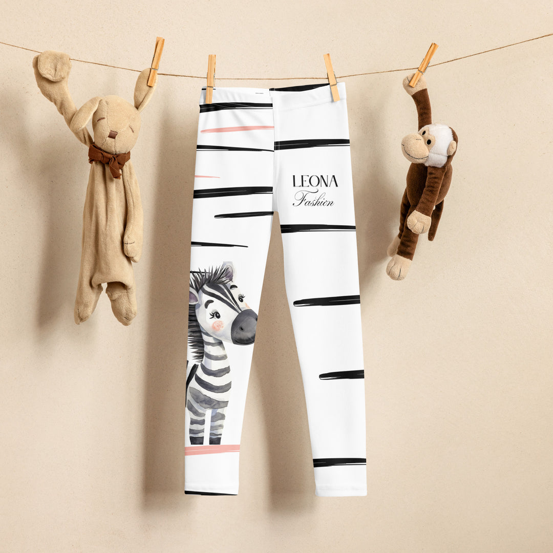 Zebra Blush Glow Girls Leggings, white with black and white zebra print and blush pink stripes, displayed hanging on a clip hanger, front view-with a visible 'Leona Fashion' text on the design