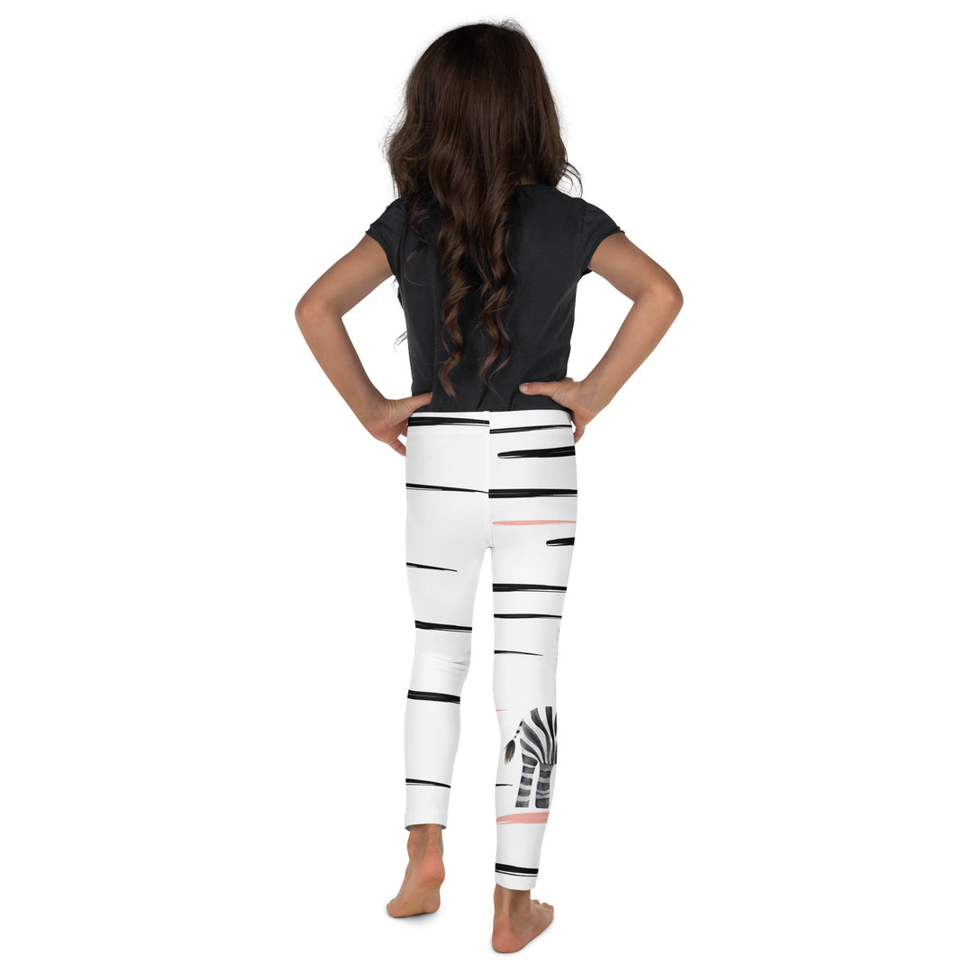 Back side of leggings on model – Zebra Blush Glow Girls Leggings, white with black and white zebra print and blush pink stripes