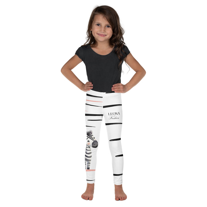 Zebra Blush Glow Girls Leggings, white with black and white zebra print and blush pink stripes – front view on model-with a visible 'Leona Fashion' text on the design