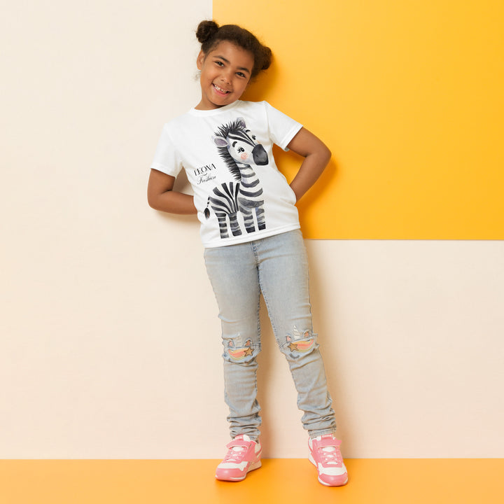 Zebra Blush Glow Girls T-shirt, white with black and white zebra print, front profile shown on model-with a visible 'Leona Fashion' text on the design
